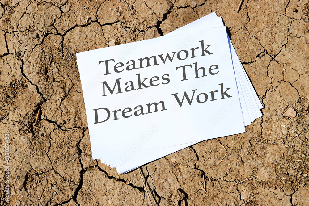 teamwork makes the dream work concept on papers on dry cracked ground