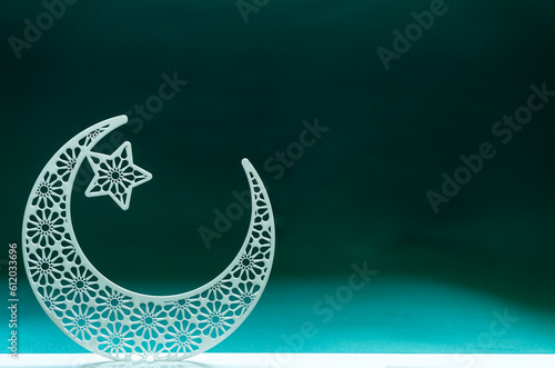 Crescent moon shape isolated on green background with copy space, Eid Mubarak design