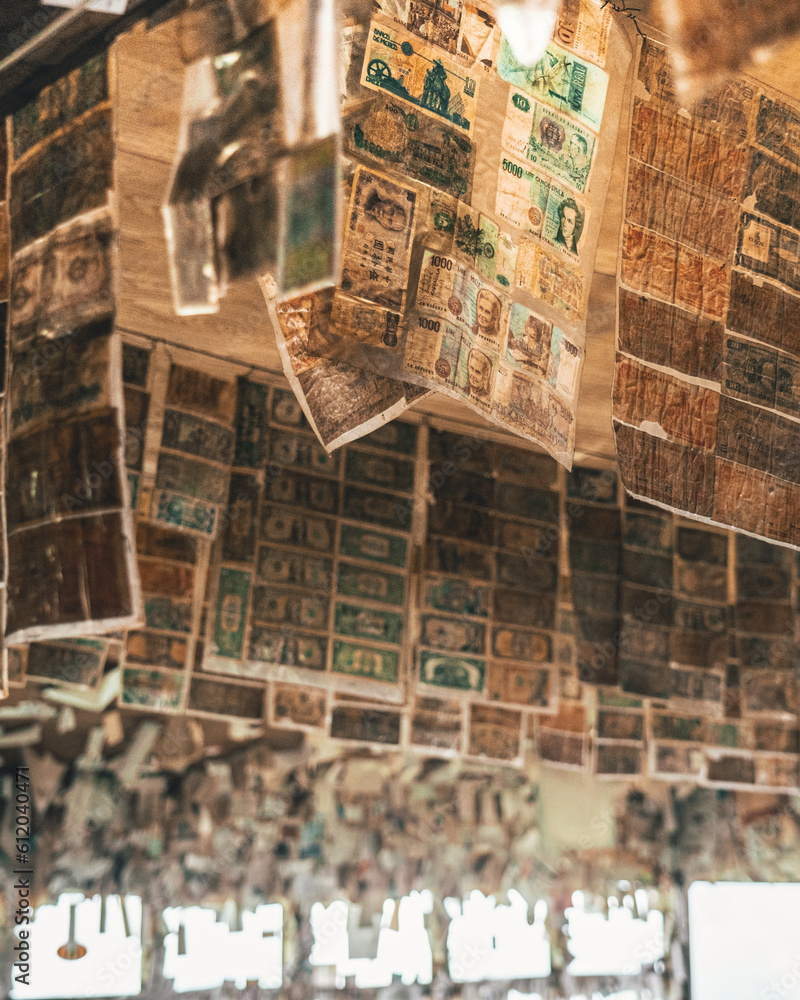 A ceiling has thousands of different bills from around the world