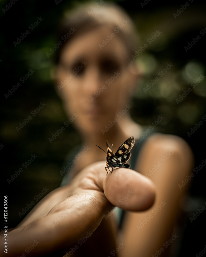 A butterfly over a woman's thumb A butterfly over a woman's thumb