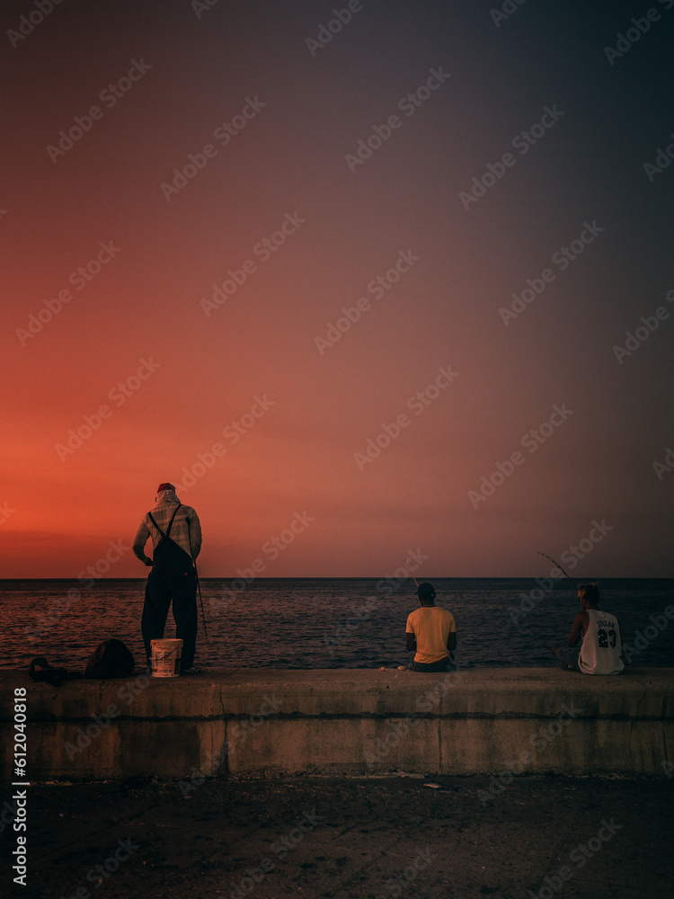 Fototapeta premium Fishermen working during sunset on Havana Malecón