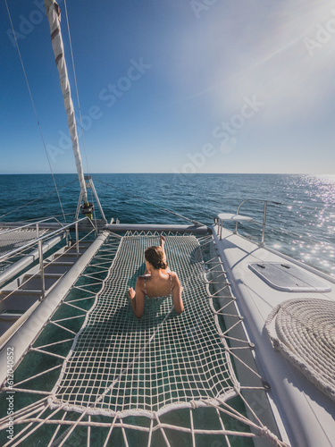 A woman on a catamaran over the sea on a sunny day