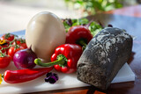 Homemade bread, ostrich egg and vegetables, paprika, tomatoes, chili, onion, salad. Ingredients for making an omelet, shakshuka. Soft selective focus.