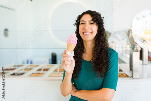 Attractive latin woman looking happy eating ice cream cone