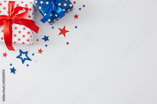Concept for patriotic presents on America's Independence Day. Top view flat lay of gift boxes, blue, red, white stars on white background with blank space for message or greeting