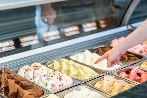 Somebody is choosing a flavor of ice cream in a store with a female assistant photo