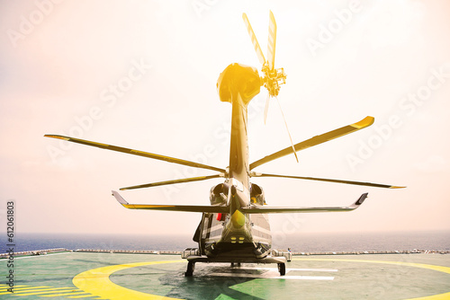 Helicopter Landing Officer communicating with pilot and copilot for service on ground and support as the pilot required. The helicopter landing on the deck in oil and gas platform