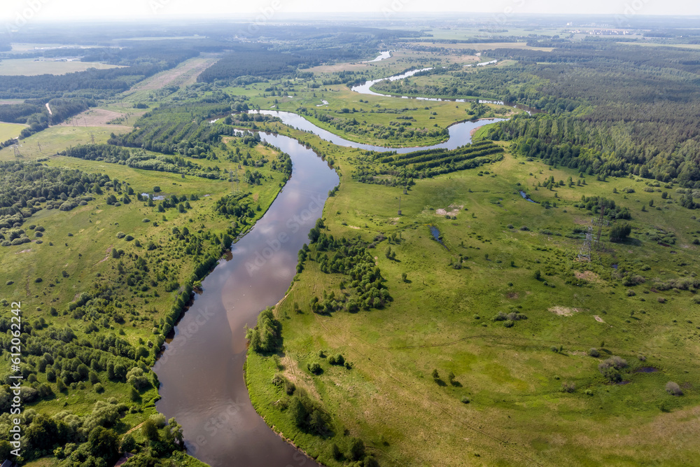 panoramic view from a high altitude of a meandering river in the forest near village