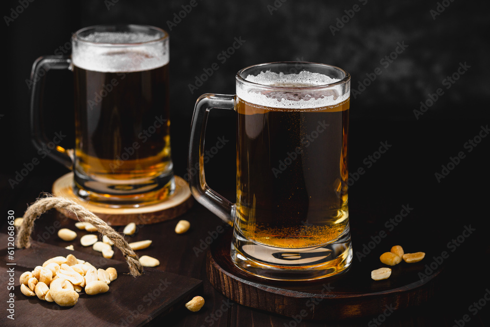 Mugs of lager beer and salty nuts. oktoberfest atmosphere, craft brewery background Mugs of lager beer and salty nuts. oktoberfest atmosphere, craft brewery background