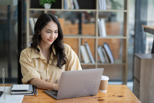 Asian woman working with laptop in her office. business financial concept.