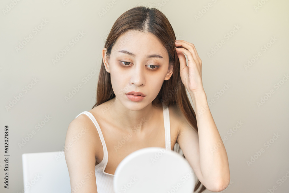Bored, insomnia asian young woman, girl looking at mirror hand touching under eyes with problem of black circles or panda puffy, swollen and wrinkle on face. Sleepless, sleepy healthcare person. Bored, insomnia asian young woman, girl looking at mirror hand touching under eyes with problem of black circles or panda puffy, swollen and wrinkle on face. Sleepless, sleepy healthcare person.