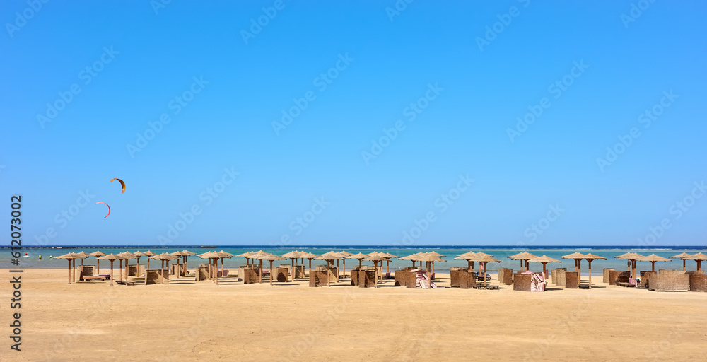 Fototapeta premium An empty beach with sun umbrellas in distance, Marsa Alam, Egypt.