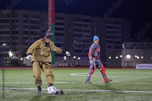 A worker plays soccer. Rope access and soccer.Mountaineers play soccer at night in the stadium. photo