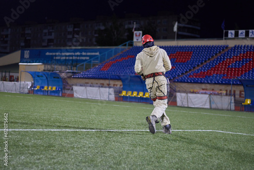 A worker plays soccer. Rope access and soccer.Mountaineers play soccer at night in the stadium. © poto8313