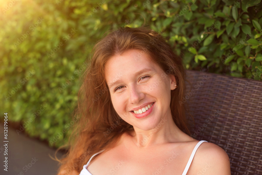 Portrait of happy beautiful young woman at sunny summer day smile and look at camera relax on natural background Portrait of happy beautiful young woman at sunny summer day smile and look at camera relax on natural background
