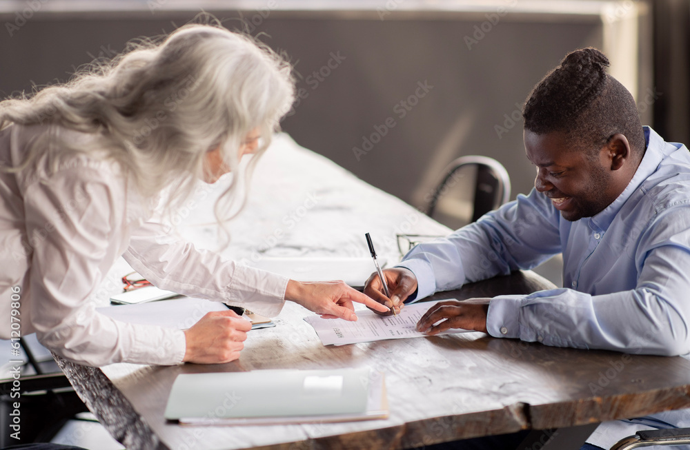 Obraz premium Manager Woman Signing Employment Contract With Employee Man In Office