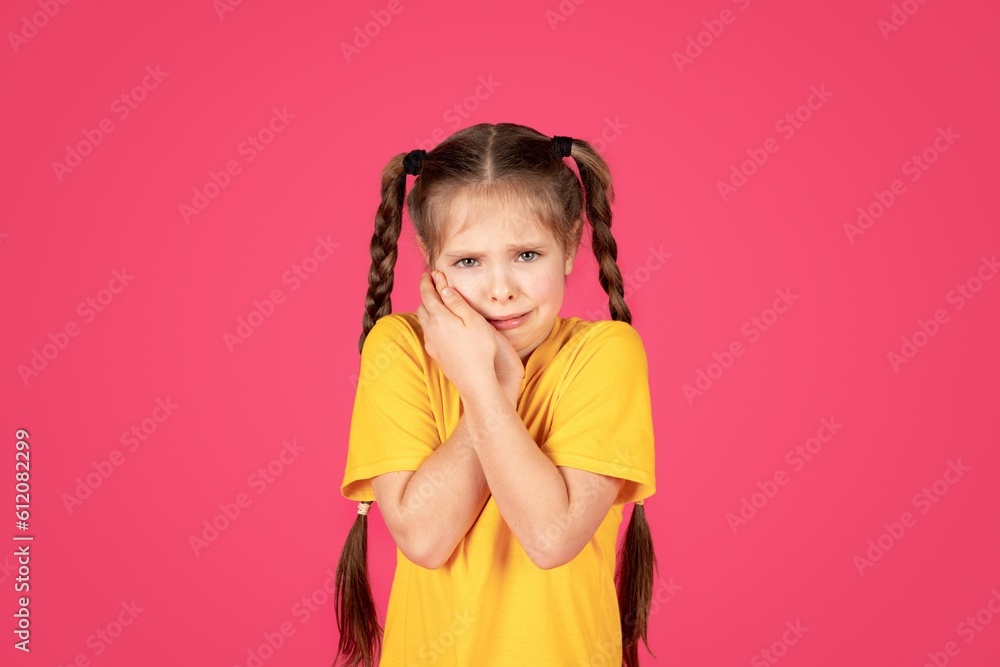 Unhappy preteen girl suffering from tooth ache, tpuching her cheek Unhappy preteen girl suffering from tooth ache, tpuching her cheek