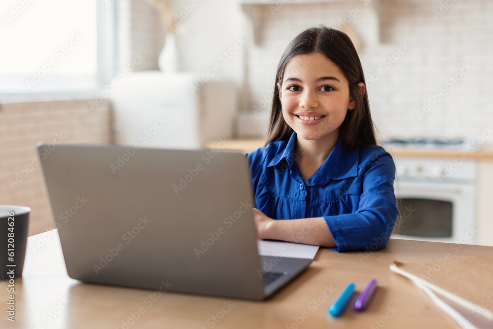 Enthusiastic Schoolgirl Engages in Online Studies Using Laptop At Home Enthusiastic Schoolgirl Engages in Online Studies Using Laptop At Home