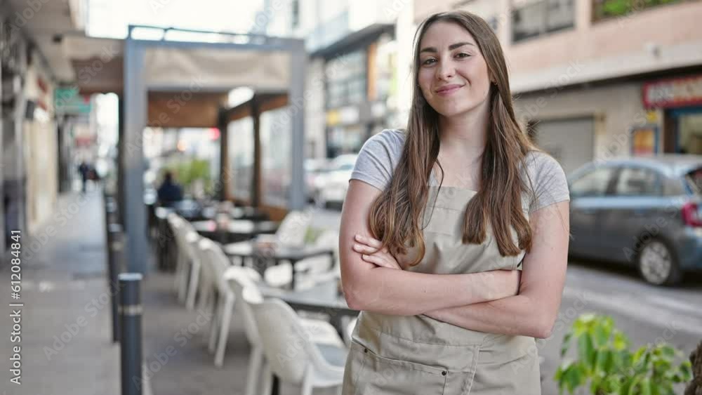 Young beautiful hispanic woman waitress smiling confident standing with arms crossed gesture at coffee shop terrace Young beautiful hispanic woman waitress smiling confident standing with arms crossed gesture at coffee shop terrace