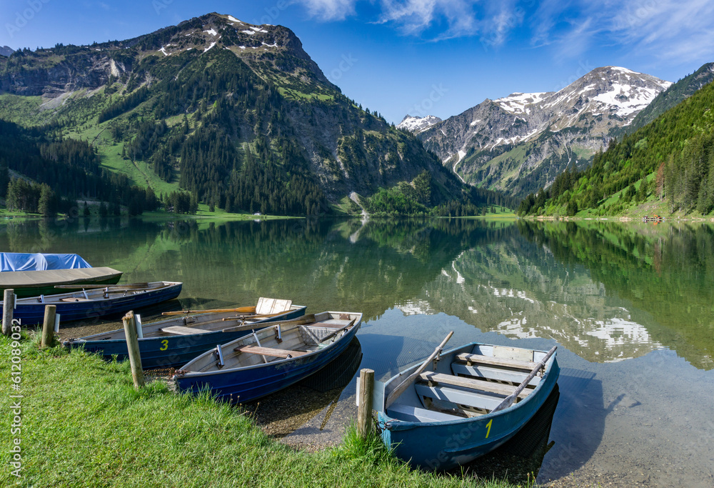 Wandern in Österreich, nahe dem Allgäu: der schöne Bergsee Vilsalpsee in den Tannheimer Bergen in Tirol beliebter Foto Hotspot in Social Media, später Frühling, früher Sommer im Mai, Boote am Rand