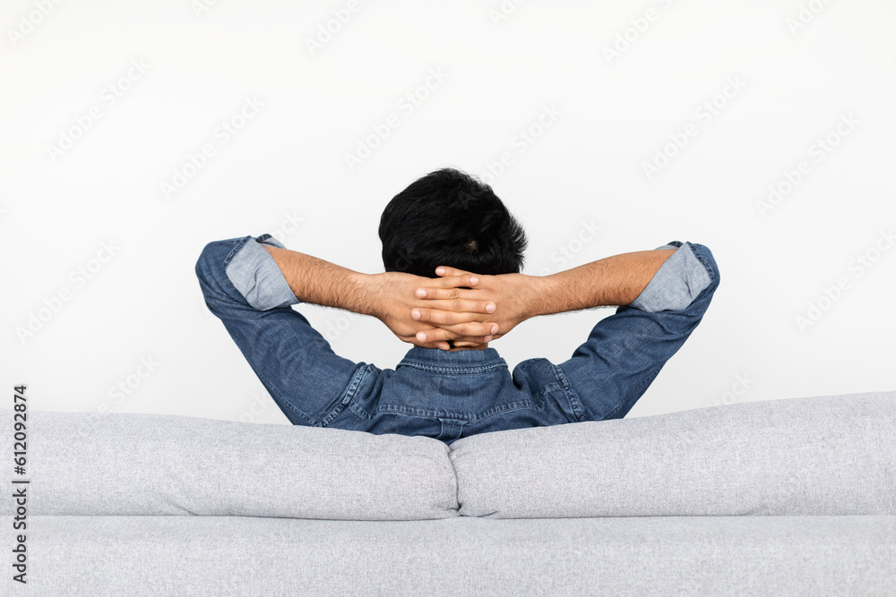 Relaxed man resting on couch at home, back view Relaxed man resting on couch at home, back view