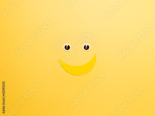Banner con emoticones de carita sonriente y banana con ojitos. espacio para texto, en fondo amarillo, concepto de dia mas feliz del año, happy yellow day, verano. photo