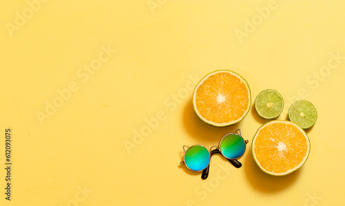 Banner con espacio para texto, frutas frescas y naturales naranjas y limones en rodajas, gafas de sol y sonrisas en fondo amarillo, concepto de dia mas feliz del año, happy yellow day, verano.