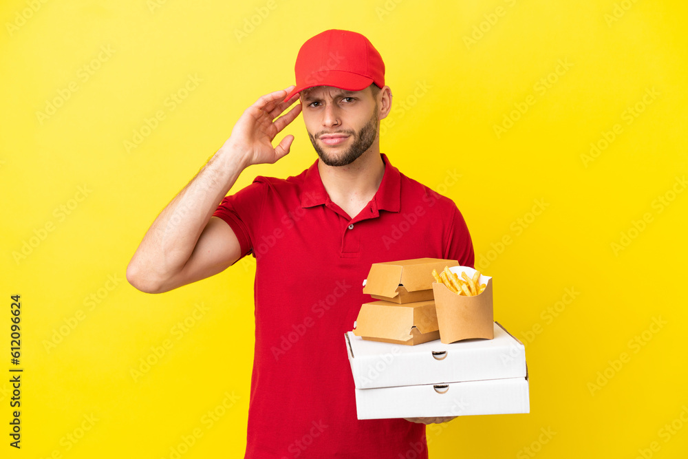 pizza delivery man picking up pizza boxes and burgers over isolated background having doubts