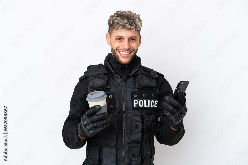SWAT caucasian man isolated on white background holding coffee to take away and a mobile SWAT caucasian man isolated on white background holding coffee to take away and a mobile