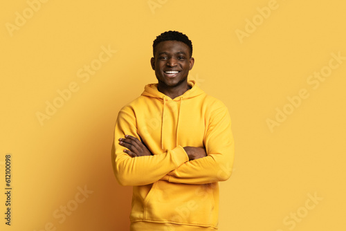 Handsome african guy in casual posing on yellow, copy space