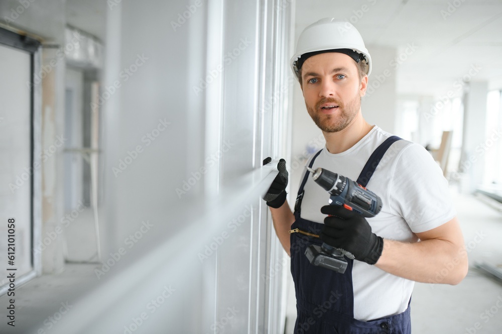 drywall worker works on building site in a house. drywall worker works on building site in a house.