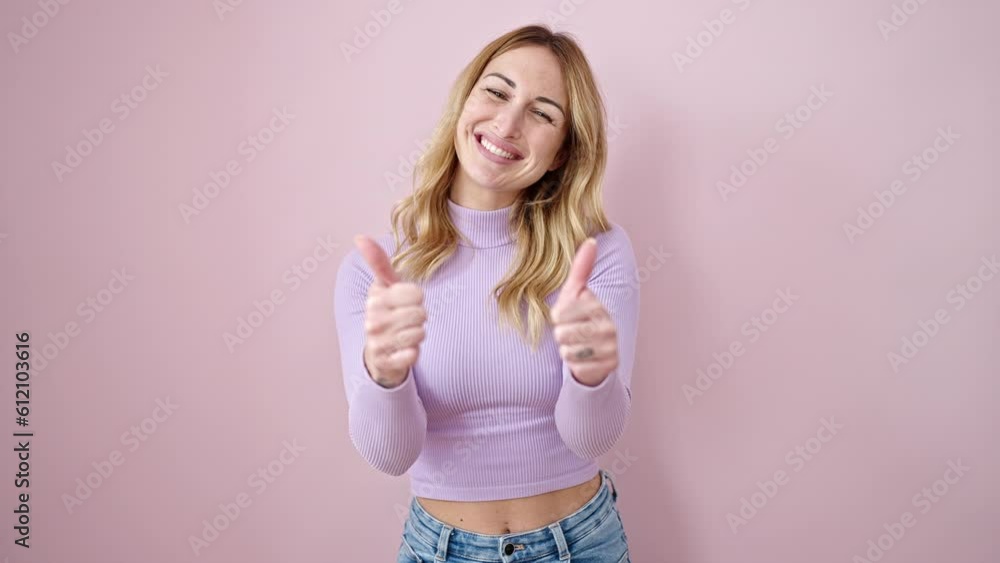 Young beautiful hispanic woman smiling with thumbs up over isolated pink background Young beautiful hispanic woman smiling with thumbs up over isolated pink background