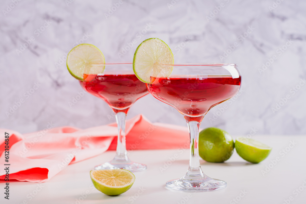 Cosmopolitan cocktail with lime in glasses on the table