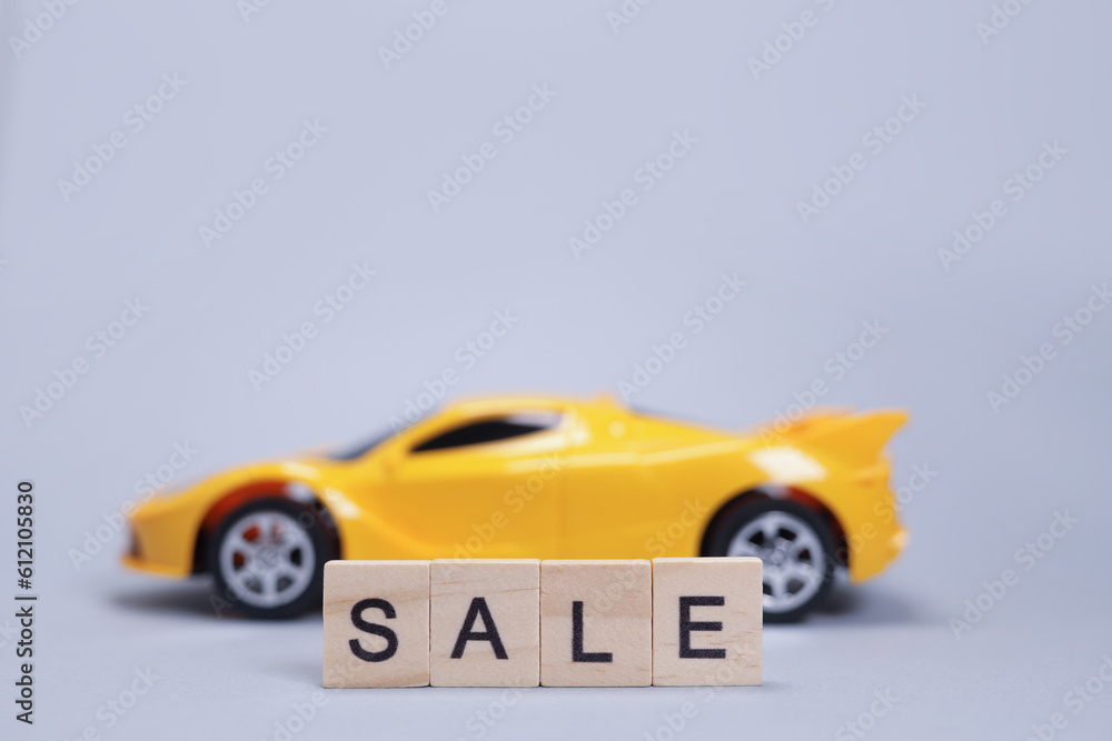 Fototapeta premium Toy car and word sale from wooden letters