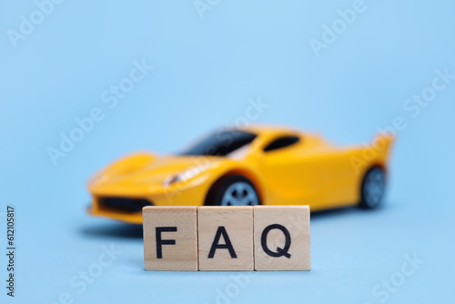 Toy car and word FAQ from wooden letters