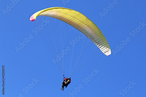  Tandem Paraglider flying in a blue sky