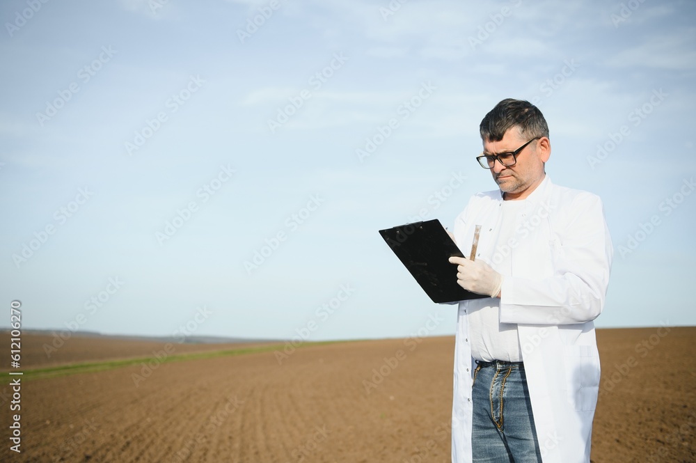 specialist checking quality of soil before planting and other hand holding notebook and pen. concept soil improvement for agriculture specialist checking quality of soil before planting and other hand holding notebook and pen. concept soil improvement for agriculture