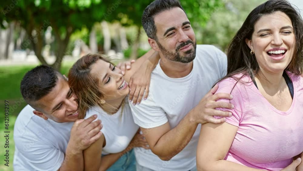 Group of people hugging each other smiling at park Group of people hugging each other smiling at park
