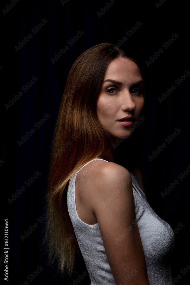 Mysterious allure and captivating gaze of a young woman in a striking studio portrait. Mysterious allure and captivating gaze of a young woman in a striking studio portrait.