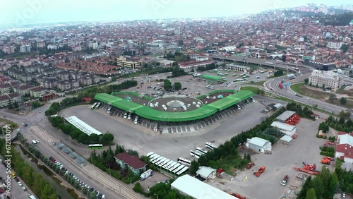 4K drone footage over bus terminus for intercity bus service. Aerial shooting of coach terminal against wide urban background stock video.