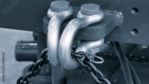 Metal shackle with chain for lifting or towing heavy objects in the workshop. Industrial concept background