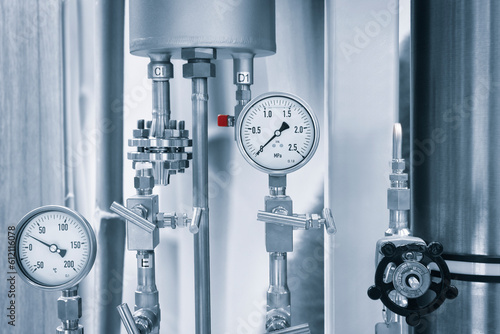 Industrial  concept. equipment of the boiler-house, - valves, tubes, pressure gauges, thermometer. Close up of manometer, pipe, flow meter, water pumps and valves of heating system in a boiler room. photo