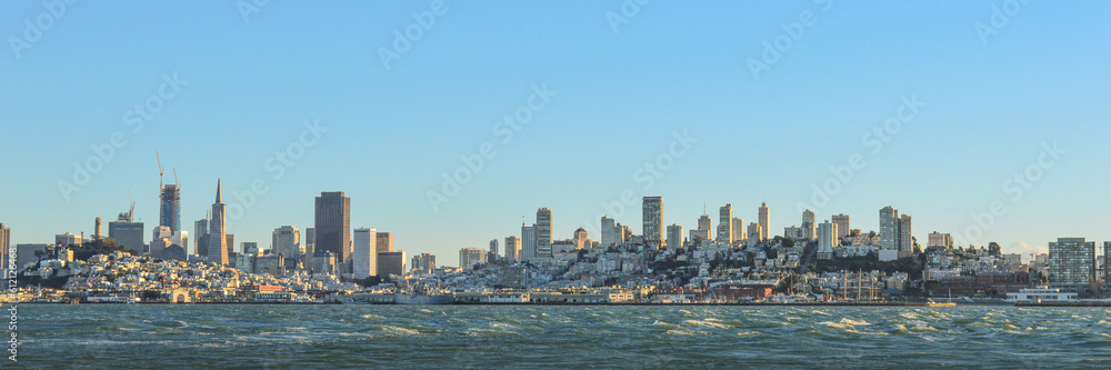 City skyline of New York City in panorama view with blue sky day, water, river below famous, cityscape area of United States of America. 