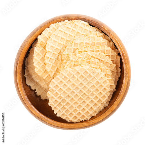 Cheese cracker in a wooden bowl. Snack in the shape of circular and wafer-thin slices, made of dough of wheat flour and cheese, baked crispy and golden brown, with a lattice pattern on the surface.