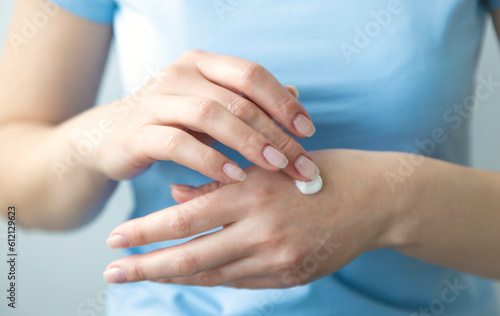 The girl applies cream on her hands. The concept of protecting and moisturizing hands in the cold season