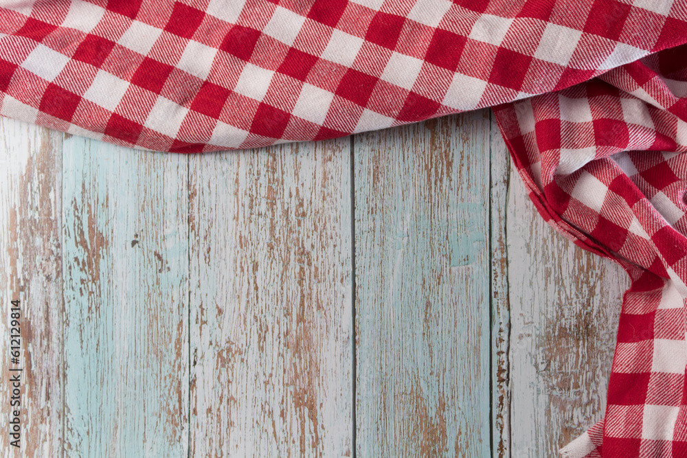 Obraz premium Red and white checkered tablecloth on a vintage wooden table