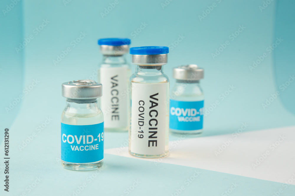 Close up shot of COVID- vaccine ampoules on pastel blue and white background with free space Close up shot of COVID- vaccine ampoules on pastel blue and white background with free space