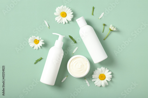 Shower gel, shampoo and hair balm packaging design with chamomile flowers on pastel green background. SPA natural organic beauty products design.