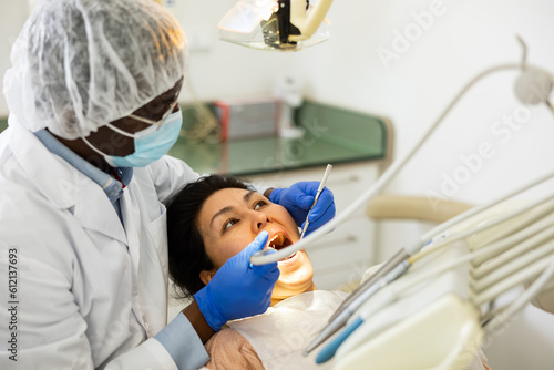 Close up view of dentist treating teeth of woman in dentist office