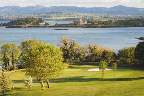 Scenic view of coastal golf hole and green and the Firth of Forth with the historic Inchcolm Abbey and the Pentland Hills from Fife, Scotland. photo